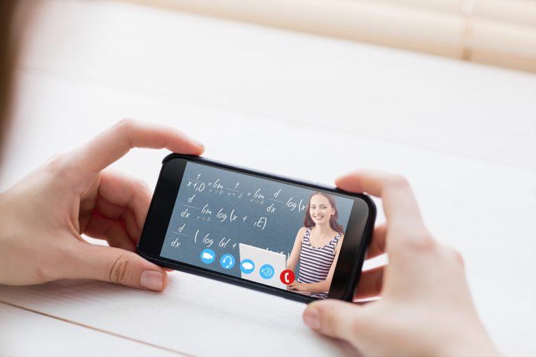 Student on laptop against cropped image of man holding smartphone